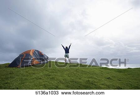 a woman camping on a grass field View Large Photo Image Stock Image - a woman camping on a grass field. Fotosearch