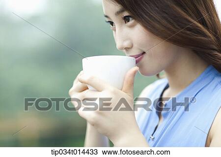 Stock Image - a woman drinking cup of coffee. Fotosearch