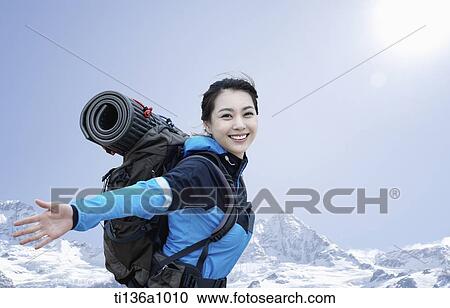 Stock Image - a woman hiking in the mountains. Fotosearch