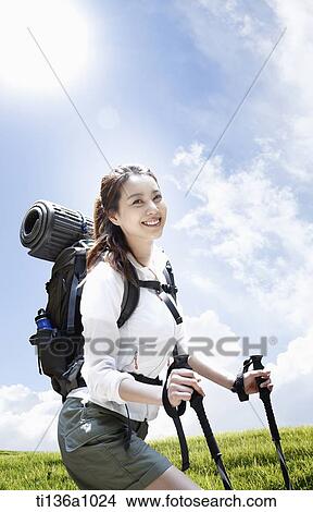 a woman hiking on a grass field View Large Photo Image Picture - a woman hiking on a grass field. Fotosearch