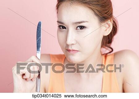 a woman holding a knife View Large Photo Image Stock Photography - a woman holding a knife. Fotosearch