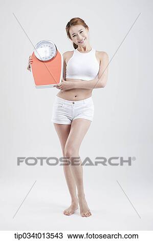 a woman holding a weighing scale View Large Photo Image Stock Image - a woman holding a weighing scale. Fotosearch