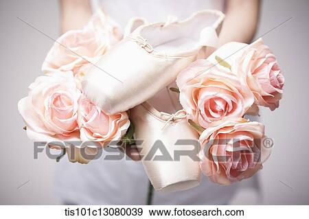 a woman holding ballet shoes on flowers View Large Photo Image Stock Photo - a woman holding ballet shoes on flowers. Fotosearch
