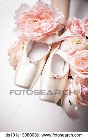 Stock Photography - a woman holding ballet shoes on flowers. Fotosearch