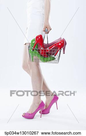 a woman in a white dress holding a cart full of heels View Large Photo Image Stock Photo - a woman in a white dress holding a cart full of heels. Fotosearch