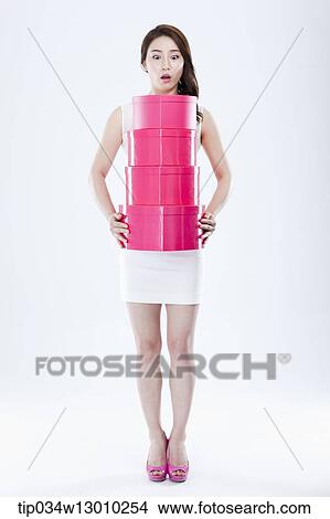 Picture - a woman in a white dress holding pink boxes. Fotosearch