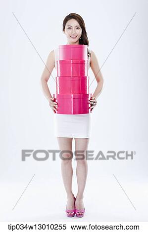 Stock Photography - a woman in a white dress holding pink boxes. Fotosearch