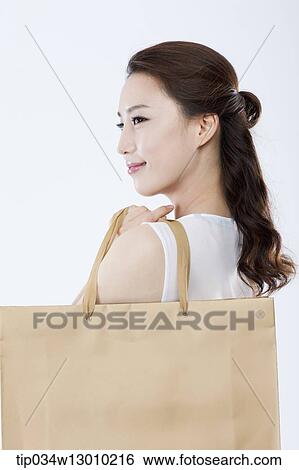 a woman in a white dress holding shopping bags View Large Photo Image Stock Photograph - a woman in a white dress holding shopping bags. Fotosearch