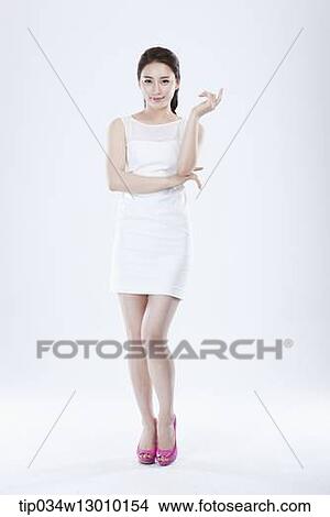 Picture - a woman in a white dress posing. Fotosearch
