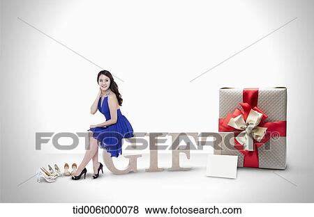 a woman in dress sitting on a word gift View Large Photo Image Stock Photo - a woman in dress sitting on a word gift. Fotosearch