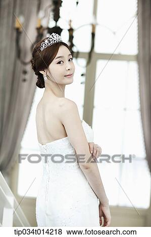 Stock Photo - a woman in wedding dress looking back. Fotosearch