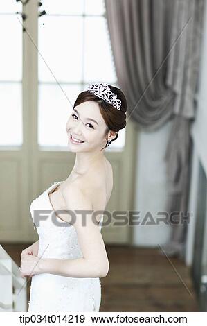 Stock Photo - a woman in wedding dress looking back. Fotosearch
