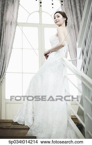 a woman in wedding dress standing on the stairs looking back View Large Photo Image Picture - a woman in wedding dress standing on the stairs looking back. Fotosearch