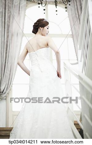 a woman in wedding dress standing on the stairs View Large Photo Image Stock Image - a woman in wedding dress standing on the stairs. Fotosearch