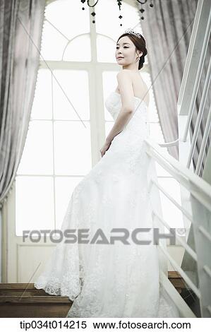 a woman in wedding dress standing on the stairs looking back View Large Photo Image Stock Photography - a woman in wedding dress standing on the stairs looking back. Fotosearch