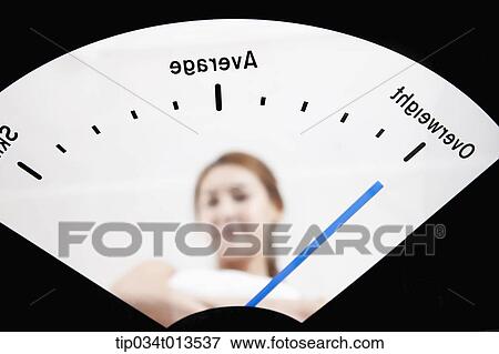 Stock Photo - a woman in weighing scale. Fotosearch