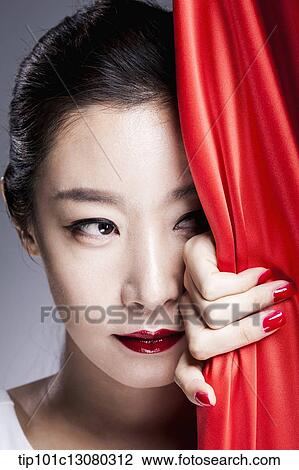a woman looking at camera behind a red curtain View Large Photo Image Stock Image - a woman looking at camera behind a red curtain. Fotosearch