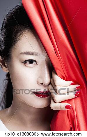 a woman looking at camera behind a red curtain View Large Photo Image Stock Photography - a woman looking at camera behind a red curtain. Fotosearch