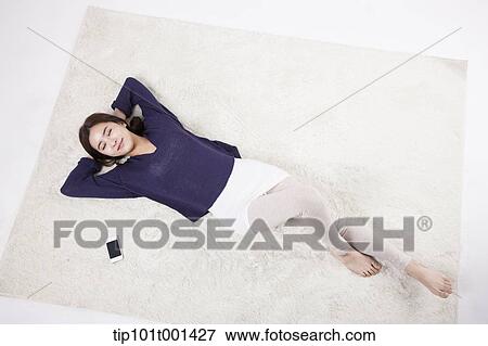 a woman lying on a carpet View Large Photo Image Stock Photo - a woman lying on a carpet. Fotosearch
