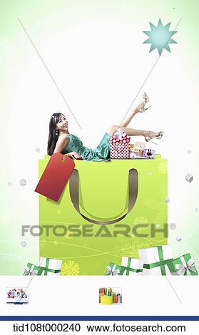 a woman lying on a shopping bag View Large Photo Image Stock Image - a woman lying on a shopping bag . Fotosearch