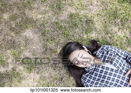 a woman lying on grass with eyes closed View Large Photo Image Stock Photography - a woman lying on grass with eyes closed. Fotosearch