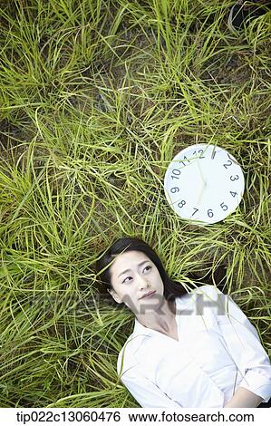 Stock Photograph - a woman lying on the grass. Fotosearch