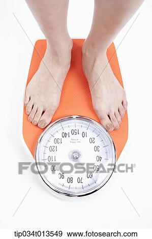 a woman measuring herself on weighing scale View Large Photo Image Stock Photo - a woman measuring herself on weighing scale. Fotosearch