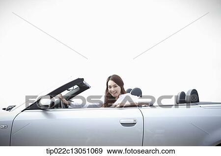 a woman next to a convertible car View Large Photo Image Stock Photo - a woman next to a convertible car. Fotosearch