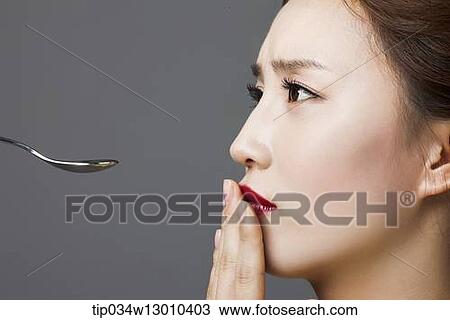 Stock Image - a woman next to a spoon. Fotosearch