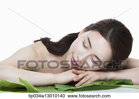 Stock Image - a woman posing next to a leaf. Fotosearch