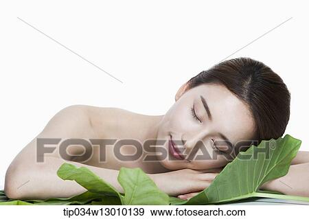 Stock Photo - a woman posing next to a leaf. Fotosearch
