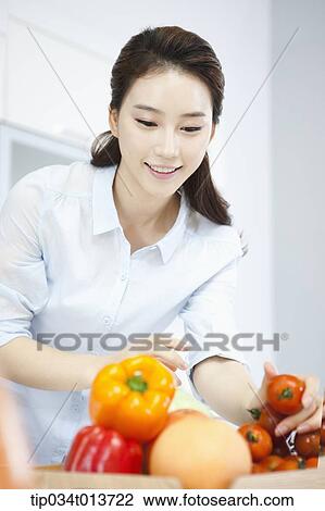 a woman putting vegetables and fruits on a tray View Large Photo Image Stock Image - a woman putting vegetables and fruits on a tray. Fotosearch