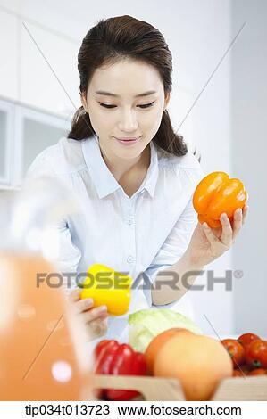 a woman putting vegetables and fruits on a tray View Large Photo Image Stock Image - a woman putting vegetables and fruits on a tray. Fotosearch