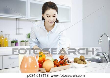 a woman putting vegetables and fruits on a tray View Large Photo Image Stock Photo - a woman putting vegetables and fruits on a tray. Fotosearch
