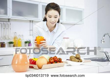 a woman putting vegetables and fruits on a tray View Large Photo Image Stock Photo - a woman putting vegetables and fruits on a tray. Fotosearch