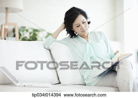 Picture - a woman reading a book. Fotosearch