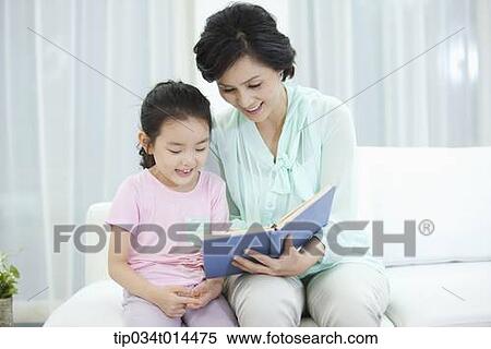 Stock Photography - a woman reading grand daughter a book. Fotosearch