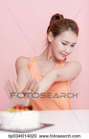 a woman saying no to a cake in front of her View Large Photo Image Stock Image - a woman saying no to a cake in front of her. Fotosearch