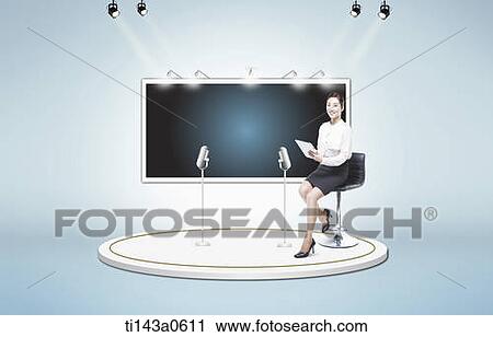 Stock Image - a woman sitting next to a big screen. Fotosearch