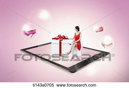 Stock Photography - a woman sitting next to a gift on a tablet. Fotosearch