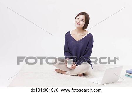 a woman sitting on a carpet with a laptop View Large Photo Image Stock Photograph - a woman sitting on a carpet with a laptop. Fotosearch