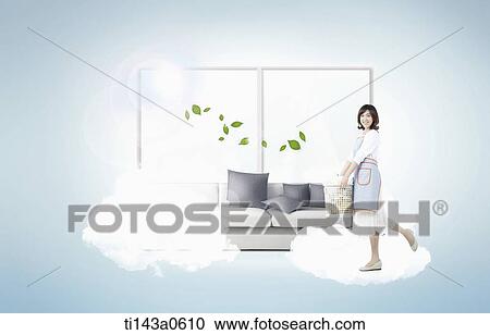 Stock Image - a woman standing next to a couch. Fotosearch