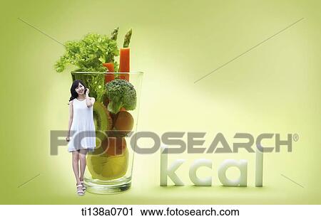 a woman standing next to a glass full of vegetables View Large Photo Image Stock Image - a woman standing next to a glass full of vegetables. Fotosearch