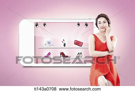 Stock Photo - a woman standing next to a smart phone. Fotosearch