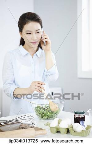 a woman talking on the phone while cooking View Large Photo Image Stock Photography - a woman talking on the phone while cooking. Fotosearch