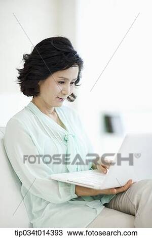Stock Image - a woman using a laptop. Fotosearch