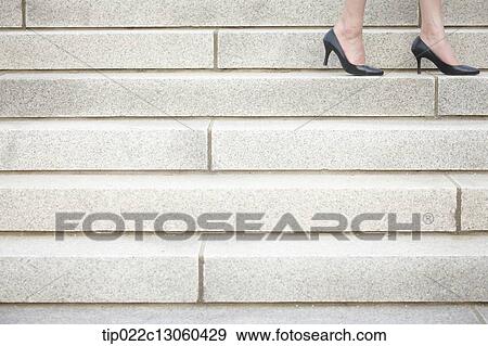 Stock Photo - a woman walking on stairs. Fotosearch