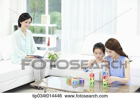 a woman watching daughter and grand daughter playing together View Large Photo Image Stock Photograph - a woman watching daughter and grand daughter playing together. Fotosearch