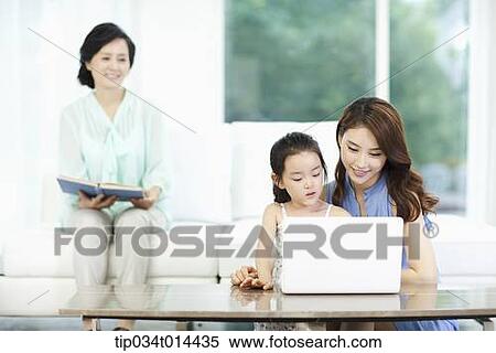 Stock Photography - a woman watching daughter and grand daughter using laptop. Fotosearch