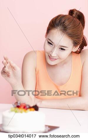 Stock Photo - a woman with a cake in front of her. Fotosearch